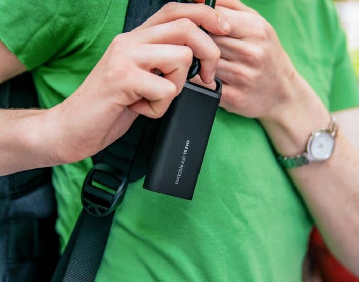 A man in a green shirt holding a cell phone